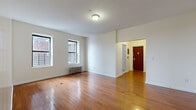 Located at 2 Osborne Terrace in Newark, NJ, this two-bedroom, one-bathroom residence offers a well-organized single-floor layout with a practical and comfortable living environment. The spacious living room is a standout feature, showcasing warm hardwood flooring that flows throughout the main living areas, crisp white walls, and two windows that allow natural light to fill the room. A cast-iron radiator provides classic heating, and an entry hallway with a distinctive red door welcomes residents upon arrival. The generously sized primary bedroom continues the hardwood flooring and includes a cast-iron radiator along with a window offering outdoor views of the surrounding neighborhood. The second bedroom is equally well-appointed with hardwood floors and its own window, providing a bright and comfortable space. The kitchen features light tile flooring, wood cabinetry, a gas range, and a stainless steel refrigerator, with a window that brings in additional natural light. The bathroom is finished with warm earth-toned tile surrounding the shower-tub combination, complemented by a white vanity with a medicine cabinet mirror, tile flooring, a window for ventilation, and a cast-iron radiator. Two hallways connect the rooms efficiently, completing this functional and well-maintained residence.
