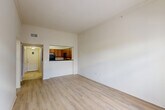 Located on Corporate Boulevard in Baton Rouge, Louisiana, this one-bedroom, one-bathroom unit is thoughtfully laid out across a single floor. The open-concept living, dining, and kitchen area serves as the heart of the home, featuring light wood-style flooring, high ceilings with crown molding, and a set of French doors topped with a transom window that floods the space with natural light and provides outdoor access. The kitchen is defined by warm wood cabinetry, dark granite countertops, a tile backsplash, and black appliances including a range, microwave, and refrigerator. A raised breakfast bar separates the kitchen from the living area, creating a natural flow between spaces. The spacious bedroom offers vaulted ceilings, a ceiling fan, and access to both the bathroom and a walk-in closet with built-in wire shelving. The full bathroom features a long vanity with dual mirrors, rich wood cabinetry, a bathtub with a shower, and large-format tile flooring. Additional highlights include a dedicated laundry area, a secondary closet, and a hallway that connects all living spaces efficiently. The unit offers a practical and comfortable layout well-suited for single occupants or couples.