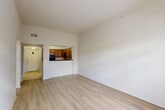 Located on Corporate Boulevard in Baton Rouge, Louisiana, this one-bedroom, one-bathroom unit is thoughtfully laid out across a single floor. The open-concept living, dining, and kitchen area serves as the heart of the home, featuring light wood-style flooring, high ceilings with crown molding, and a set of French doors topped with a transom window that floods the space with natural light and provides outdoor access. The kitchen is defined by warm wood cabinetry, dark granite countertops, a tile backsplash, and black appliances including a range, microwave, and refrigerator. A raised breakfast bar separates the kitchen from the living area, creating a natural flow between spaces. The spacious bedroom offers vaulted ceilings, a ceiling fan, and access to both the bathroom and a walk-in closet with built-in wire shelving. The full bathroom features a long vanity with dual mirrors, rich wood cabinetry, a bathtub with a shower, and large-format tile flooring. Additional highlights include a dedicated laundry area, a secondary closet, and a hallway that connects all living spaces efficiently. The unit offers a practical and comfortable layout well-suited for single occupants or couples.