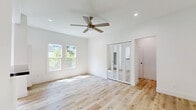Located at 1800 El Cerrito Place in the desirable Los Feliz neighborhood of Los Angeles, this thoughtfully designed unit makes excellent use of its single-floor layout. Light hardwood flooring runs throughout, creating a warm and cohesive foundation that ties the space together seamlessly.

The open-concept kitchen and living area serves as the heart of the unit. The kitchen is outfitted with crisp white shaker cabinetry, matte black hardware, and striking black marble-veined countertops that extend to a peninsula — providing both additional prep space and a natural divider between the kitchen and living area. A stainless steel sink with a matte black faucet adds a refined, modern touch.

The living area benefits from large double-hung windows that invite generous natural light and offer lush, green outdoor views, giving the space an airy and bright ambiance. A ceiling fan with a wood-toned finish adds a casual, comfortable feel.

The mirrored bi-fold closet doors in the living area reflect light effectively, enhancing the sense of openness. An arched hallway entry adds a subtle architectural detail that lends charm to the overall design.

The bathroom is a standout space, featuring full-wall black hexagonal mosaic tile in the tub/shower surround, dark marble-look floor tile, a classic pedestal sink, and matte black fixtures — delivering a bold, high-contrast aesthetic that feels both stylish and intentional.