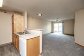 Located at 8711 Northpark Ct in Urbandale, Iowa, this one-bedroom, one-bathroom unit offers a practical and comfortable single-floor layout. The open-concept kitchen and living area serves as the heart of the home. The kitchen features warm oak cabinetry, white appliances including a range, over-the-range microwave, refrigerator, and dishwasher, along with a double-basin sink and light wood-style flooring. A peninsula counter connects the kitchen to the living area, which is finished with plush carpet, a ceiling fan, and a sliding glass door that invites natural light and provides outdoor access. The spacious bedroom is carpeted and includes a closet and a window that brings in additional natural light. A versatile den offers flexible space for a home office or additional storage, also with carpeted flooring and its own closet. Three closets throughout the unit provide generous storage options. The full bathroom includes a tub/shower combo, a vanity, and built-in over-toilet shelving. Textured ceilings and warm neutral tones are consistent throughout, creating a cohesive and functional living environment.