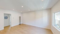 This thoughtfully designed single-floor unit offers a clean, modern aesthetic throughout, characterized by crisp white walls, smooth ceilings, and light-toned hardwood flooring that flows seamlessly from room to room. Recessed lighting illuminates the generously sized living areas, creating a bright and airy atmosphere. A wall-mounted heating unit provides efficient climate control in the main living space, which also benefits from natural light through well-placed windows. The fully equipped kitchen is a standout feature, boasting white shaker-style cabinetry, grey countertops, and a classic white subway tile backsplash. Stainless steel appliances — including a refrigerator with ice maker, gas range, over-the-range microwave, and dishwasher — complete the functional and stylish space. The bedrooms are well-proportioned and bright, with one featuring a ceiling fan and a mirrored sliding-door closet that enhances the sense of space. The bathrooms are finished to a high standard, with marble-look countertops, undermount sinks, large wall mirrors, and one full bathroom featuring a tiled tub-shower combination enclosed by sliding glass doors. The overall design is clean, minimal, and move-in ready.