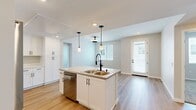 This thoughtfully designed single-story residence in Redlands, CA offers a clean, modern aesthetic with an efficient and well-organized floor plan. The open-concept living area seamlessly connects the kitchen, dining, and living spaces, creating a bright and cohesive environment. Light wood-look flooring flows throughout the main living areas, complemented by neutral walls and recessed lighting that enhance the airy feel.

The kitchen serves as the focal point of the home, featuring a generous center island with a quartz countertop, a double-basin sink with a matte black faucet, white shaker cabinetry with black hardware, stainless steel appliances, and stylish pendant lighting overhead. Ample pantry storage adds to the kitchen's practicality.

Both bedrooms are carpeted for comfort and receive natural light through slatted windows. The primary bedroom offers a comfortable footprint with dedicated closet space. Each of the two full bathrooms is finished with light wood-look flooring, white cabinetry with black hardware, and a tub-shower combination. Additional conveniences include an in-unit laundry area, two closets, and a private balcony. The consistent use of white tones, matte black accents, and modern fixtures gives the entire space a cohesive, contemporary character.