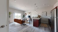 Located at 50 Carlisle Springs Rd in Carlisle, PA, this single-floor residence offers a thoughtfully designed open-concept layout that seamlessly connects the kitchen, dining, and living areas. The living room is bright and welcoming, featuring light gray hardwood-style flooring, neutral walls, and a sliding glass door that opens to a private balcony with outdoor views — allowing natural light to fill the space throughout the day.

The kitchen is well-equipped with rich dark cabinetry, light quartz-style countertops, and a full suite of stainless steel appliances including a refrigerator, electric range, and built-in microwave. A peninsula with pendant lighting overhead creates a natural divide between the kitchen and living area, while also providing additional seating and prep space.

The bedroom offers a calm retreat with plush carpeting, neutral wall tones, and ample closet storage, creating a cozy and functional space. The bathroom is clean and efficiently laid out, with dark hardwood-style flooring, a shower with curtain enclosure, and a modern toilet — finished in a crisp gray-and-white palette.

Overall, the unit presents a modern, cohesive aesthetic with consistent finishes throughout, making it a comfortable and functional living space in the heart of Carlisle, Pennsylvania.