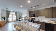 This single-story residence in Bryan, Texas offers a thoughtfully designed open-concept layout that seamlessly connects the kitchen, dining, and living areas. The kitchen is a standout feature, showcasing dark wood cabinetry, granite countertops, a tile backsplash, and a full suite of black appliances including a range, microwave, dishwasher, and refrigerator. A generous granite-topped breakfast bar with seating provides an ideal space for casual dining or entertaining. Track lighting overhead and wood-look flooring throughout the main living areas add a modern, cohesive aesthetic.

The living room is bright and welcoming, benefiting from natural light through large windows and a sliding glass door that opens to a private balcony. A ceiling fan adds comfort to the space. The bedrooms are carpeted for warmth and feature natural light from well-positioned windows with ceiling fans included. The primary suite includes a tiled walk-in shower and an organized walk-in closet with built-in shelving. Additional bedrooms are served by dedicated closet space and are accessible via carpeted hallways. The overall ambiance is contemporary and well-appointed throughout.
