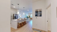 Located in Palm Coast, Florida, this single-story 2-bedroom, 2-bathroom home offers a well-designed open-concept layout that seamlessly connects the kitchen, dining, and living areas. The kitchen is a standout feature, showcasing sage-toned shaker cabinets, quartz countertops, a subway tile backsplash, stainless steel appliances, and a large central island with pendant lighting — ideal for both cooking and casual dining. Light wood-look flooring flows throughout, complementing the bright, white walls and airy atmosphere.

The living room is bathed in natural light from large windows and is enhanced by a ceiling fan, creating a comfortable and inviting retreat. A private patio provides an outdoor extension of the living space. The primary bedroom features soaring ceilings, direct access to a full bathroom with a soaking tub and subway tile surround, and a generously sized walk-in closet with built-in shelving. The second bedroom is well-proportioned with convenient access to the adjacent bathroom. Additional highlights include five closets, a dedicated pantry, and an in-unit laundry room, ensuring ample storage and functional everyday living throughout the home.