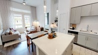This single-floor residence at 3451 N Plano Rd in Richardson, Texas, presents a thoughtfully designed open-concept layout bathed in natural light. The kitchen serves as a central hub, showcasing gray flat-front cabinetry, white quartz countertops, a full suite of stainless steel appliances, a subway tile backsplash, and a freestanding center island with pendant lighting overhead. The soaring ceilings amplify the sense of space throughout the main living area.

The living room benefits from floor-to-ceiling French doors that invite natural light and provide views of the surrounding exterior, complemented by transom windows that further brighten the space. The open dining area connects seamlessly to both the kitchen and living room, creating a cohesive flow ideal for entertaining.

Multiple bedrooms offer carpeted flooring, generous windows with outdoor views, and ample closet space. The bathrooms feature wood-look tile flooring, dual vanities with quartz countertops, gray cabinetry, and a tub-shower combination. A walk-in closet adjacent to the primary bath adds practical storage. Throughout the residence, the clean white walls, warm wood-tone accents, and consistent modern finishes establish a bright, contemporary ambiance.