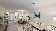 This well-appointed single-story unit in Metairie, Louisiana, offers a thoughtfully designed layout that maximizes functionality and comfort. The open-concept living and dining area forms the heart of the home, featuring rich hardwood-style flooring, neutral toned walls, and ample natural light streaming through large windows dressed with decorative curtains. The living space provides a welcoming atmosphere, while the adjacent dining area is accented by a stylish chandelier overhead.

The galley-style kitchen is efficiently arranged with light wood cabinetry, white appliances including a refrigerator, electric range, and microwave, as well as light-colored countertops that contribute to a clean, bright aesthetic. A pass-through opening connects the kitchen to the dining and living areas, enhancing the sense of openness.

The bedroom is a restful retreat featuring plush carpet, a ceiling fan, a window with natural light, and direct access to a spacious walk-in closet. The full bathroom includes a single vanity with a large mirror, built-in shelving for storage, and a shower-tub combination.

A dedicated laundry area with a full-size washer and dryer adds significant convenience. A hallway connects all areas of the unit, maintaining a practical and efficient flow throughout. This unit is an ideal option for those seeking comfortable, single-level living in the Metairie area.
