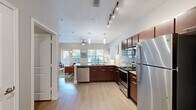 Located at 3819 Harry Wurzbach Rd in San Antonio, TX, this single-floor unit offers a well-designed open layout that maximizes every square foot. The main living area features light hardwood-style flooring, neutral walls, and vaulted ceilings that enhance the sense of space and airiness. A ceiling fan adds comfort, while large windows invite natural light and views of the surrounding greenery.

The kitchen is a standout feature, designed with rich dark-wood cabinetry, granite countertops, a subway tile backsplash, and a full suite of stainless steel appliances including a range, microwave, dishwasher, and refrigerator. Pendant lighting over the peninsula adds a modern touch, and the open pass-through design keeps the kitchen connected to the living space.

The bathroom is clean and functional, featuring a tub-shower combination with white tile surround, a dark-wood vanity with granite countertop, and hardwood-style flooring that ties in with the rest of the unit. A dedicated closet provides organized storage, completing the practical layout. The overall ambiance is modern, bright, and welcoming — ideal for those seeking a comfortable, well-appointed space in San Antonio.