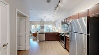 Located at 3819 Harry Wurzbach Rd in San Antonio, TX, this single-floor unit offers a well-designed open layout that maximizes every square foot. The main living area features light hardwood-style flooring, neutral walls, and vaulted ceilings that enhance the sense of space and airiness. A ceiling fan adds comfort, while large windows invite natural light and views of the surrounding greenery.

The kitchen is a standout feature, designed with rich dark-wood cabinetry, granite countertops, a subway tile backsplash, and a full suite of stainless steel appliances including a range, microwave, dishwasher, and refrigerator. Pendant lighting over the peninsula adds a modern touch, and the open pass-through design keeps the kitchen connected to the living space.

The bathroom is clean and functional, featuring a tub-shower combination with white tile surround, a dark-wood vanity with granite countertop, and hardwood-style flooring that ties in with the rest of the unit. A dedicated closet provides organized storage, completing the practical layout. The overall ambiance is modern, bright, and welcoming — ideal for those seeking a comfortable, well-appointed space in San Antonio.