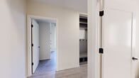 Located in Chicago's vibrant River North neighborhood, this thoughtfully designed 2-bedroom, 2-bathroom residence offers a refined urban living experience across a single floor. The open-concept kitchen serves as a centerpiece, featuring a waterfall-edge island with a two-tone gray and white cabinetry palette, stainless steel appliances, subway tile backsplash, and striking matte black pendant lighting beneath an exposed concrete ceiling that adds industrial character to the space. Light-toned hardwood flooring flows throughout, lending warmth and continuity. The bedrooms offer a tranquil retreat, with the primary bedroom boasting floor-to-ceiling sliding glass doors that frame serene outdoor greenery views, filling the room with natural light. Both bathrooms are finished to a high standard, featuring gray shaker-style vanities with white quartz countertops, backlit mirrors, white subway tile surrounds, and matte black fixtures accented with brass hardware details — one with a soaking tub and one with a glass-enclosed walk-in shower. The hallways are well-proportioned and include a built-in mudroom-style closet with shelving, hooks, and bench seating, providing smart storage solutions. The overall ambiance is clean, contemporary, and functional.