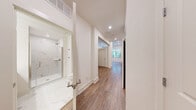 Located at 95 Maple St in Stoneham, MA, this thoughtfully designed one-bedroom, one-bathroom residence offers a modern and efficient layout across a single floor. Warm hardwood flooring flows throughout, complemented by crisp white walls and recessed lighting that create a clean, contemporary aesthetic.

The open-concept kitchen and living area serves as the heart of the unit. The kitchen is outfitted with light wood flat-panel cabinetry extending floor to ceiling, a marble-style tile backsplash, white quartz countertops, and a full suite of stainless steel appliances including a range, microwave, dishwasher, and refrigerator. Large windows allow abundant natural light to fill the combined living space.

A hallway connects the main living area to the private bedroom, which features hardwood floors, neutral walls, and a wide window overlooking the surrounding greenery — ideal for natural light and ventilation. A ceiling fan adds comfort to the space. Two closets provide ample storage.

The bathroom is finished to a high standard, showcasing marble-look porcelain tile on both the floors and the walk-in shower surround. A frameless glass shower door with brushed nickel hardware and a floating wood vanity complete the refined look. In-unit laundry adds further convenience to this well-appointed Stoneham residence.
