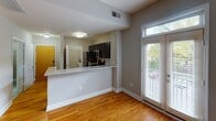 Located at 916 W Fifth St in Charlotte, NC, this single-floor unit offers a well-designed layout that balances functionality and modern style. The open entryway welcomes you with warm hardwood flooring that extends throughout the main living areas, creating a cohesive and inviting atmosphere. Natural light filters in through windows fitted with blinds, brightening the space comfortably.

The kitchen is a standout feature, equipped with dark espresso cabinetry, granite countertops, a subway tile backsplash, and a full suite of stainless steel appliances including an electric range, built-in microwave, and dishwasher. A peninsula counter separates the kitchen from the living area, providing additional workspace and an informal dining option.

The bedroom is a well-proportioned, quiet space with the same warm hardwood flooring, neutral gray walls, and a ceiling fan with integrated lighting. A closet offers wire shelving and a hanging rod for organized storage.

The bathroom features light gray tile flooring, a dark wood vanity with a granite countertop, and a full tub and shower combination with classic white subway tile surround. The overall design is clean, neutral, and move-in ready.