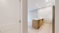 Located at 7 Erskine Lane in Victoria, BC, this well-appointed one-bedroom, one-bathroom unit offers a thoughtfully designed single-floor layout finished with contemporary touches throughout. Light hardwood flooring runs continuously across the living spaces, complementing the warm, neutral-toned walls and crisp white trim.

The open-concept kitchen and living area serves as the heart of the unit. The kitchen is equipped with stainless steel appliances — including a refrigerator, electric range, and dishwasher — paired with white upper cabinetry, light wood lower cabinetry, and clean white quartz countertops. A peninsula with an integrated sink provides additional workspace and casual dining potential, while recessed lighting overhead ensures a bright, functional environment.

The living area benefits from soaring ceilings and large windows that frame lush, tree-lined views, flooding the space with natural light. A wall-mounted mini-split heat pump offers efficient year-round climate control.

The bedroom is a comfortable, well-proportioned retreat with a dedicated window overlooking greenery and a baseboard heater for supplemental warmth. A closet provides convenient storage. The bathroom is finished with marble-look tile flooring, a light wood vanity with quartz countertop, and a full tub-shower combination, maintaining the clean, modern aesthetic found throughout the home.