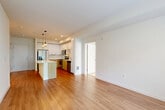 Located at 2681 Tagore Avenue NE in Redmond, WA, this 2-bedroom, 2-bathroom residence offers a thoughtfully designed single-level layout. The open-concept living and kitchen area serves as the heart of the home, featuring warm hardwood-style flooring, crisp white walls, and large windows that flood the space with natural light and provide views of the surrounding greenery. Stylish pendant lighting accents the kitchen island, which anchors the cooking space alongside two-tone cabinetry — white upper cabinets paired with natural wood lower cabinets — a subway tile backsplash, and a full suite of stainless steel appliances including a refrigerator, range, microwave, and dishwasher. Both bedrooms are generously proportioned, with the primary bedroom offering plush carpeting and ample closet space via walk-in closets with wire shelving systems. The second bedroom features hardwood-style flooring and a large window with outdoor views. Each bathroom is finished with wood-toned vanity cabinetry, white countertops, and a tub-shower combination. With four closets throughout, storage is well-accommodated. The overall aesthetic is clean, modern, and bright, creating a comfortable and functional living environment.