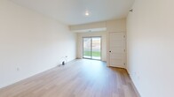 This single-floor unit on Daylight Drive in Sioux Falls, South Dakota offers a clean, contemporary design throughout. The kitchen serves as a functional centerpiece, featuring stainless steel appliances including a refrigerator, electric range, and built-in microwave, paired with warm-toned cabinetry and a spacious island with a light countertop and integrated sink. Pendant lighting above the island adds a modern touch, while light wood-style flooring flows through the kitchen and living areas, creating a cohesive, bright atmosphere.

The living area is open and well-lit, with a sliding glass door that provides direct access to the outdoors and fills the space with natural light. Additional rooms feature neutral carpet, offering a softer feel, and windows that bring in outside views. The bathroom is thoughtfully appointed with wood-style flooring, dark-finish cabinetry, a full tub-shower combination, and modern matte black hardware accents.

A dedicated laundry area includes a top-load washer and wall-mounted wire shelving for added storage convenience. Throughout the unit, crisp white walls, panel-style interior doors, and recessed lighting contribute to a clean, move-in-ready aesthetic suited to everyday living.