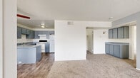 Located at 3955 E Charleston Blvd in Las Vegas, NV, this single-floor unit offers three bedrooms and one bathroom within a practical and efficiently organized floor plan. The open-concept living and dining area features plush wall-to-wall carpeting and a textured ceiling, creating a neutral and versatile backdrop. Adjacent to the living space, the kitchen is well-equipped with gray cabinetry extending to the upper walls, a speckled gray laminate peninsula countertop, wood-look vinyl flooring, a white electric range, refrigerator, and a double-basin sink — all providing functional workspace for daily use. The three bedrooms are carpeted and finished with clean white walls. The primary bedroom includes a dedicated closet with built-in shelving and benefits from a sliding glass door that opens to an outdoor area, allowing natural light to fill the room. An additional bedroom features its own closet storage. The shared full bathroom is finished in white, featuring a tub/shower combo with tiled surround, wood-look flooring, and chrome fixtures. A dedicated closet provides extra storage within the unit. The overall aesthetic is clean and understated, well-suited for comfortable everyday living in a central Las Vegas location.