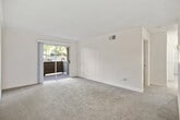 Located at 301 W Vermont Ave in Escondido, California, this 2-bedroom, 1-bathroom single-floor unit offers a well-organized layout designed for comfortable everyday living. The living room is a bright, open space featuring plush carpeting, a textured ceiling, and a sliding glass door that opens to a private balcony overlooking a landscaped outdoor area — allowing natural light to fill the room. A ceiling fan adds to the comfort of the adjacent area near the entryway, which connects seamlessly to the kitchen. The galley-style kitchen is thoughtfully designed with white shaker cabinetry, dark granite countertops, wood-look flooring, and black appliances including a range and dishwasher. The primary bedroom offers a comfortable footprint with mirrored sliding closet doors and carpeted flooring, while the second bedroom features its own window with blinds and plush carpet. The shared full bathroom is appointed with a tub and shower combination, wood-look tile flooring, a dark granite vanity countertop, and a large mirror. Throughout the unit, textured ceilings and neutral tones create a clean, cohesive aesthetic well-suited to a variety of living arrangements.