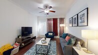 This single-floor residence in Killeen, Texas offers a well-designed layout that balances comfort and functionality throughout. The living room serves as the heart of the home, featuring rich hardwood-style flooring, crown molding, and a ceiling fan overhead. Large windows dressed with bold patterned curtains allow natural light to fill the space, creating a bright and inviting atmosphere. A dedicated dining area adjacent to the living space provides an intimate setting for meals, framed by crisp white walls. The kitchen is efficiently designed with dark cabinetry, black appliances including a refrigerator, stove, and built-in microwave, along with a breakfast bar that connects seamlessly to the main living areas. The bedrooms are carpeted and well-proportioned, each featuring windows with blinds that allow for adjustable natural light. Two full bathrooms are finished with hardwood-style flooring, vanities with dark cabinetry, and shower-tub combinations, offering practical and clean spaces. Throughout the home, the consistent use of hardwood-style flooring in the main areas and neutral wall tones creates a cohesive and polished aesthetic. The single-level floorplan ensures easy accessibility and efficient flow between all areas of the home.