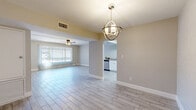 Located at 1132 N Dodge Blvd in Tucson, Arizona, this single-story 2-bedroom, 2-bathroom home offers a thoughtfully designed layout with modern finishes throughout. Light wood-look tile flooring flows seamlessly across all rooms, giving the space a clean, cohesive aesthetic.

The open living and dining area is bright and welcoming, anchored by a striking orb-style chandelier and a ceiling fan that adds both function and style. Large sliding glass doors dressed with vertical blinds fill the space with natural light and provide outdoor views. The living area connects effortlessly to the dining space, creating an open, airy feel ideal for entertaining.

The kitchen is a functional highlight, featuring white cabinetry with granite-look countertops, a subway tile backsplash, stainless steel appliances including a refrigerator and dishwasher, and a skylight that floods the room with natural light.

The spacious primary bedroom offers a ceiling fan, a large window, and exposed white-painted brick accent walls that add character and texture. A generous walk-in closet with built-in shelving and hanging rods provides ample storage. The second bedroom also features a ceiling fan, natural light, and track lighting.

Both bathrooms are clean and functional, with one featuring a full tub-shower combo with white surrounds and tile-look flooring. The home's neutral palette and updated finishes create a bright, move-in-ready atmosphere throughout.