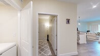 Located at 747 N DuPont Hwy in Dover, Delaware, this well-appointed 2-bedroom, 1-bathroom residence offers a thoughtfully designed open-concept layout finished with warm, neutral tones and wood-look flooring throughout. The combined kitchen and living area serves as the heart of the home, where a sleek kitchen showcases white shaker cabinetry, dark countertops, stainless steel appliances, a tile backsplash, and a peninsula with bar seating illuminated by stylish pendant lighting. The living room is bright and welcoming, featuring large sliding glass doors that invite natural light and offer views of the outdoors. Both bedrooms are comfortably sized, with the primary bedroom offering a generous footprint, large windows dressed with sheer curtains, and ample natural light. The second bedroom includes a double-door closet and wood-look flooring, providing flexible use as a guest room or home office. The bathroom is equipped with a dual-sink vanity featuring white cabinetry and dark countertops, complemented by a large wall mirror. A dedicated closet adds convenient storage. The consistent use of neutral finishes and modern fixtures creates a cohesive, contemporary ambiance throughout the entire space.