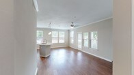 Located in Houston's 77077 zip code, this single-story residence offers a well-designed open-concept layout that seamlessly connects the living area and kitchen. The living space is finished with warm hardwood-style flooring, crown molding, and a ceiling fan, while multiple windows flood the interior with abundant natural light and provide views of the surrounding greenery. A private entry door with sidelights adds character to the main living area.

The kitchen is well-appointed with dark espresso cabinetry, granite countertops, stainless steel appliances including an electric range and microwave, and a double-basin stainless steel sink. A central kitchen island provides additional workspace and storage, while multiple windows create a bright, airy atmosphere in the dining area adjacent to the kitchen.

The bedrooms feature plush carpeting, ceiling fans, and generous windows that bring in natural light. Each bedroom includes access to a walk-in closet with built-in shelving, offering substantial storage capacity.

The bathrooms echo the kitchen's design aesthetic, featuring dark cabinetry paired with granite countertops, hardwood-style flooring, and tiled tub-shower combinations, creating a cohesive and polished finish throughout the home.
