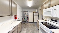 This 1910 square foot single-story facility in Akron, Ohio, offers a blend of functional spaces designed for various uses. The kitchen area features a galley-style layout with ample cabinetry, white appliances, and a practical tile floor. Adjacent to the kitchen, a large open area serves as a multi-purpose room, equipped with round tables and chairs, ideal for gatherings or meetings. The space boasts drop ceilings with recessed lighting, providing even illumination throughout.

Multiple rooms showcase different color schemes and setups, including a room with peach-colored walls and blue carpeting, perfect for smaller group activities. The facility also includes storage areas with metal shelving units and a refrigerator for additional convenience. Carpeted floors in the main areas offer comfort and noise reduction, while the suspended ceiling tiles contribute to the building's acoustics and lighting efficiency.

The versatile nature of this space is evident in its ability to accommodate various setups, from classroom-style arrangements to open floor plans for larger events. With its mix of private rooms and open areas, this facility is well-suited for community gatherings, educational purposes, or as a flexible workspace for organizations requiring adaptable environments.