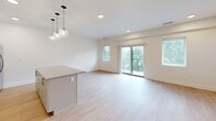 Located at 1862 E 123rd St in Cleveland, Ohio, this well-appointed single-story home offers three bedrooms, two bathrooms, and a thoughtfully designed layout that maximizes comfort and functionality. The open-concept kitchen and living area serves as the heart of the home, showcasing light hardwood-style flooring, recessed lighting, and stylish globe pendant lights above a granite-topped island. The kitchen features white cabinetry, stainless steel appliances, and clean modern lines. The living area extends toward a sliding glass door that opens to a private balcony, bringing in generous natural light and outdoor views. The generously sized primary bedroom includes a ceiling fan, plush carpeting, and a large sliding glass door with vertical blinds offering balcony access. The additional bedrooms are carpeted and well-proportioned, each with ceiling fans and ample natural light. Both bathrooms are finished with contemporary details — one highlights a walk-in shower with white subway tile, a glass sliding door, and brushed gold hardware, while the second features a neutral vanity with under-sink storage and light tile flooring. A hallway and dedicated closet round out the floor plan, providing practical storage solutions throughout this clean and move-in-ready home.