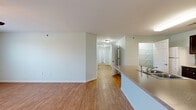 This single-story, 3-bedroom, 2-bathroom residence offers a thoughtfully designed layout across a comfortable footprint. The open-plan kitchen and living area serves as the heart of the home, featuring wood-look flooring, a peninsula with a granite-style countertop and built-in sink, and a kitchen equipped with dark espresso cabinetry, white appliances, and a glass-panel accent wall. The living area flows seamlessly from the kitchen, providing an open and airy feel.

The primary bedroom is a generously sized retreat, highlighted by a ceiling fan with light fixture, a window with an outdoor view of mature trees, and continued wood-look flooring. Two additional bedrooms feature soft wall-to-wall carpeting and soft sage-toned walls, offering comfortable, versatile spaces. Both bathrooms are finished with wood-look flooring and include accessibility-friendly grab bars.

Storage is well-addressed throughout, with two closets fitted with wire shelving systems. A dedicated laundry room includes washer/dryer hookups and additional wire shelving. Two hallways connect the rooms efficiently. The consistent light sage wall palette and clean white trim lend a cohesive, calm ambiance throughout the entire residence.