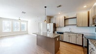 Located at 955 North Orlando Avenue in Maitland, FL, this well-appointed 2-bedroom, 2-bathroom residence offers a thoughtfully designed single-floor layout with modern finishes throughout. The open-concept living, dining, and kitchen area serves as the heart of the home, where light wood-style flooring, recessed lighting, and neutral tones create a bright and welcoming atmosphere. The kitchen is a standout feature, showcasing light wood cabinetry, a white subway tile backsplash, granite countertops, a granite-topped center island with pendant lighting, and a full suite of stainless steel appliances. The spacious primary bedroom benefits from multiple windows that invite abundant natural light, complemented by a ceiling fan and generous closet space complete with wire shelving systems. The second bedroom is equally comfortable, featuring its own window and ceiling fan. Both bathrooms are finished with granite vanity tops, light wood cabinetry, and clean white tile. A dedicated laundry area adds everyday convenience. Throughout the residence, consistent wood-style flooring, soft gray walls, and clean white trim contribute to a cohesive, contemporary aesthetic suited for comfortable living in the heart of Maitland.