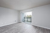 This single-floor unit offers a clean, modern aesthetic throughout, with a thoughtful layout that maximizes functionality and comfort. The open living area is finished with light wood-look luxury vinyl plank flooring and features a ceiling fan with built-in lighting. A large sliding glass door floods the space with natural light and provides outdoor access, while neutral-toned walls create a calm, versatile backdrop. Adjacent to the living area, the kitchen is well-equipped and designed for efficiency, showcasing crisp white shaker cabinetry, light countertops, stainless steel appliances including a dishwasher and refrigerator, a stainless steel sink, and coordinating light flooring. A dedicated bedroom offers plush wall-to-wall carpeting, a window with blinds for natural light and privacy, and a recessed ceiling light. The bathroom is bright and functional, featuring a full tub and shower combination, a toilet, and light tile-style flooring, all finished in white for a clean, airy feel. A hallway with a closet connects the spaces seamlessly, completing this well-organized and move-in ready layout.