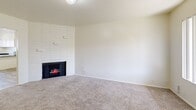 Located in Taylorsville, Utah, this single-floor, 2-bedroom, 1-bathroom unit offers a well-organized layout with a clean, neutral palette throughout. The living room serves as the heart of the home, anchored by a striking white-brick corner fireplace that adds warmth and character. Plush wall-to-wall carpet runs underfoot, and the open sight line into the combined kitchen and dining area creates a connected, functional flow. The kitchen features wood-look vinyl flooring, dark countertops, white cabinetry, a stainless refrigerator, and a window that brings in natural light. A dedicated pantry provides additional storage. The spacious primary bedroom opens directly onto a private balcony through a sliding glass door, offering outdoor views and natural light. The second bedroom features soft carpet and a bright window with vertical blinds. Both bedrooms are served by a full bathroom finished with wood-look flooring, a single-sink vanity with dark countertop, and a tub-shower combo. The unit also includes a utility room, a dedicated hallway, and an impressive five closets distributed throughout, ensuring ample storage. Wood-look flooring in the secondary spaces complements the carpeted living and sleeping areas for a cohesive, practical finish.