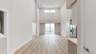 Located at 825 S Coronado St in Los Angeles, this modern two-story residence offers three bedrooms and two bathrooms across a thoughtfully designed layout. The main level commands attention with soaring double-height ceilings in the open-concept living area, bathed in natural light from large windows and sliding glass doors that lead to a private balcony with sweeping city views. Light-toned hardwood flooring runs throughout, enhancing the bright, airy atmosphere.

The contemporary kitchen is well-appointed with sleek flat-front cabinetry, stainless steel appliances including a French door refrigerator, range, microwave, and dishwasher, complemented by clean white countertops. The main level also includes hallways, closets, and a dedicated laundry area for added convenience.

The bedrooms offer a serene retreat, with the generously sized primary bedroom featuring a closet and access to city-facing views. Additional bedrooms are well-proportioned, with plush carpeting in some rooms and hardwood in others. The bathrooms are finished in a clean, minimalist style, including a full tub-shower combination with white tile surround. The upper level provides additional flexible living space with its own natural light and views.
