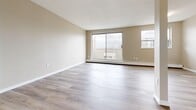 Located at 800 Exmouth St in Sarnia, Ontario, this 2-bedroom, 1-bathroom unit offers a well-organized single-floor layout designed for comfortable everyday living. Light-toned vinyl plank flooring runs throughout the space, lending a clean and cohesive aesthetic across every room.

The combined kitchen and living area forms the heart of the unit. The kitchen is outfitted with crisp white shaker-style cabinetry, dark granite-look countertops, a white subway tile backsplash, and stainless steel appliances including a Whirlpool range and refrigerator. The adjacent living area is generously proportioned, featuring large sliding glass doors that open to a balcony, filling the room with natural light and offering views of the surrounding neighbourhood.

Both bedrooms are bright and functional, each featuring wide windows that invite natural light and baseboard heating units. The primary bedroom includes a full-width built-in closet with sliding doors, providing ample storage. The second bedroom also benefits from good natural light and a practical layout.

The bathroom is finished with neutral-toned tile flooring, a tiled tub-shower surround, and a white vanity with cabinet storage. Throughout the unit, warm beige walls and white trim create a neutral, move-in-ready atmosphere suited to a variety of personal styles.