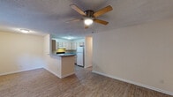 Located at 4016 Copperfield Dr in New Bern, NC, this single-floor residence offers a practical and comfortable layout designed for everyday living. The open-concept living and dining area is finished with durable wood-look laminate flooring and features a ceiling fan with light fixture overhead. A textured ceiling runs throughout the common areas, adding a classic touch to the interior. Natural light filters in through a window fitted with blinds, offering views of the surrounding greenery outside.

The kitchen is efficiently designed with a raised peninsula that separates it from the living space, providing additional counter space and a casual dining option. Light wood cabinetry offers ample storage, complemented by blue-gray laminate countertops and a white appliance suite including a coil-burner range with overhead ventilation hood and a full-size refrigerator.

The bedrooms are carpeted for comfort and include windows with blinds to allow natural light. Each room is neutral in tone, offering a versatile canvas for personalization. The bathrooms feature wood-look vinyl flooring, a full tub-shower combination with a white surround, and standard fixtures, providing clean and functional spaces. An electrical panel is conveniently accessible within the unit.