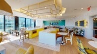 Located at 1000 Lake St in Oak Park, Illinois, this single-floor amenity space offers a thoughtfully designed environment that blends bold aesthetic choices with functional, community-focused areas. The interiors are defined by a striking mid-century modern design language, featuring a vibrant yellow and teal color palette, patterned upholstery, and carefully curated furnishings throughout.

The social lounge and kitchen area serves as a central hub, showcasing bold yellow cabinetry, marble-topped islands, and a dramatic geometric ceiling installation. Multiple seating arrangements — including bar stools, plaid armchairs, and café-style tables — make this space ideal for casual gatherings or events. A beverage tap station adds a hospitality-forward touch.

Adjacent lounge areas offer a more intimate atmosphere, with rich hardwood flooring, teal herringbone wallcovering, a marble fireplace flanked by built-in shelving, and a coffered ceiling with dark wood accents. A stone accent wall adds a natural, grounding contrast to the space's vibrant design elements.

Floor-to-ceiling glass walls in the living lounge areas frame sweeping panoramic views of the Oak Park skyline and surrounding greenery, flooding the space with natural light. A wraparound outdoor terrace extends the living space further, offering open-air seating with commanding elevated views. Together, these areas create a dynamic and visually engaging environment designed for both relaxation and socializing.