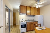 Located at 307 Thompson St in Ann Arbor, MI, this efficient one-bedroom, one-bathroom unit offers a well-organized layout across a single floor. Light hardwood-style flooring runs throughout, creating a cohesive and clean aesthetic.

The combined kitchen and dining area serves as the functional heart of the unit, featuring warm wood cabinetry with ample upper storage, granite-look countertops, a full-size refrigerator, and an electric range with oven. A ceiling fan overhead provides air circulation, and a small dining table with chairs fits comfortably within the space.

The spacious primary bedroom receives generous natural light through a wide bank of windows dressed with vertical blinds, and includes a wall-mounted air conditioning unit for climate control. The room accommodates a bed, seating, and additional furniture with ease. Two closets provide practical storage throughout the unit.

The bathroom is neatly appointed with a tub/shower combination, a vanity with sink, wood-toned cabinetry above, and tile-style flooring. A hallway connects the main living areas to the bathroom and closets, keeping the layout organized and functional. This unit is well-suited for a student or solo occupant seeking a practical residence in a prime Ann Arbor location.