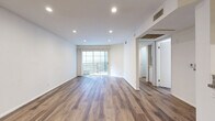 Located at 5555 N St Andrews Pl in Los Angeles, CA, this 1-bedroom, 2-bathroom unit offers a thoughtfully designed single-level layout. The open-concept living and kitchen area is the heart of the home, featuring warm wood-style flooring that extends throughout the space. Recessed lighting illuminates the bright, white walls, while a sliding glass door floods the room with natural light and provides direct access to a private balcony, ideal for enjoying the Southern California climate.

The kitchen is well-appointed with white shaker cabinetry, granite countertops, a stainless steel sink, and a full suite of stainless steel appliances including a gas range and refrigerator. Ample upper and lower cabinet storage adds practical functionality.

The bedroom offers a comfortable, well-proportioned retreat, complemented by two dedicated closets for generous storage. Two full bathrooms serve the unit, each featuring wood-style flooring; one includes a full tub and shower combination with clean white tile surround.

A hallway connects the living areas to the private quarters, contributing to a logical and efficient floor plan. The unit's clean, modern aesthetic — defined by neutral tones, consistent flooring, and updated finishes — creates a cohesive and inviting ambiance throughout.