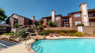 Located at 5740 Remington Cir in Fort Worth, Texas, this single-floor residence is part of a well-maintained brick exterior community with classic architectural detailing, including prominent chimneys and balconied upper levels set against lush landscaping. The community grounds feature a standout resort-style pool area complete with a decorative rock waterfall, sun loungers, and a spacious poolside deck — an inviting outdoor retreat.

Inside, the kitchen is thoughtfully updated with dark espresso cabinetry, subway tile backsplash, light granite-style countertops, stainless steel appliances including a range, microwave, and refrigerator, and durable wood-look plank flooring that extends throughout the main living areas.

The bedroom is generously sized with plush carpeting, a ceiling fan with lighting, and a bold accent wall in deep slate gray. Large sliding glass doors with vertical blinds open directly to an outdoor balcony, allowing natural light to fill the space.

The bathroom is clean and modern, featuring dark wood cabinetry, a wide vanity with a white countertop, a framed mirror, and bright overhead lighting. The overall interior offers a cohesive, contemporary aesthetic with warm tones and functional finishes throughout.