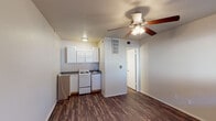Located at 504 Kemp Blvd in Wichita Falls, Texas, this single-floor unit offers a practical and straightforward layout designed for comfortable everyday living. Rich, dark wood-look flooring runs throughout the main living areas, providing a cohesive and easy-to-maintain surface underfoot.

The open living area is well-lit by a window fitted with horizontal blinds, allowing natural light to filter in while maintaining privacy. A ceiling fan with an integrated light fixture keeps the space comfortable year-round. The layout connects seamlessly to the kitchen, which is positioned along one wall and features white cabinetry, dark granite-style countertops, a white electric range, a stainless steel dishwasher, and a single-basin sink — providing all essential cooking and prep amenities in a compact, efficient footprint.

The bedroom continues the same wood-look flooring and neutral wall tones, with its own ceiling fan and a window that brings in additional natural light. A closet and doorway connect the bedroom to the rest of the unit, ensuring a functional flow between spaces.

The bathroom is clean and straightforward, outfitted with a full tub-shower combination surrounded by classic white tile, offering a simple and functional bathing space. Overall, this unit presents a clean, no-frills interior with consistent finishes throughout.