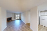 Located at 1174 Hooke Rd NW in Edmonton, Alberta, this 2-bedroom, 1-bathroom unit offers a well-organized, single-floor layout with a clean, neutral aesthetic throughout. Light hardwood-style flooring flows seamlessly across the main living areas, complementing the crisp white walls and textured ceilings. The open-concept living and dining area is a standout feature, anchored by a wood-burning fireplace with a warm wood surround and a large sliding glass door that opens to a private balcony, filling the space with natural light and outdoor views. Adjacent to the dining area, the kitchen is efficiently designed with ample white cabinetry, white countertops, a tile backsplash, a stainless steel sink, and a dishwasher. A central hallway connects the two well-proportioned bedrooms, each featuring natural light from windows, baseboard heating, and generous closet storage — with five closets distributed throughout the unit. The bathroom is finished with light hardwood-style flooring, a wide vanity with a large mirror, and a tub-shower combination clad in elegant marble-style tile. The overall ambiance is bright, clean, and move-in ready.