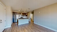 Located on Republic Drive in Colorado Springs, Colorado, this single-floor residence offers a thoughtfully designed open-concept layout with modern finishes throughout. The living area features smooth hardwood-style flooring, neutral warm-toned walls, and a glass door that opens to a private balcony, framing sweeping views of the surrounding Colorado landscape and distant mountain peaks, filling the space with natural light.

The kitchen is a standout feature, equipped with dark espresso cabinetry that reaches toward the ceiling for ample storage, stainless steel appliances including a refrigerator, range, and microwave, and a classic white subway tile backsplash. A generous granite-topped island with a built-in sink serves as a central hub for both meal preparation and casual dining, with pendant lighting above adding a refined touch.

The bedroom is carpeted for comfort and features a ceiling fan, along with multiple windows that invite natural light and offer picturesque views of the Colorado Springs skyline and mountains beyond. The bathroom includes a full tub and shower combination with white tile surround, brushed nickel fixtures, and wood-look flooring, maintaining a clean and cohesive aesthetic. This well-appointed residence balances contemporary design with functional living in a desirable Colorado Springs location.