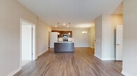 This single-story residence in Montgomery, Illinois offers a well-designed open-concept layout that seamlessly connects the kitchen, dining, and living areas. The kitchen serves as the focal point of the main living space, featuring a large central island with a built-in sink and white countertops, dark espresso cabinetry, stainless steel appliances including a range, microwave, and refrigerator, and pendant lighting overhead. A chandelier illuminates the adjacent dining area, while recessed lighting throughout enhances the bright, airy atmosphere. Wood-look luxury vinyl plank flooring extends across the main living areas, adding warmth and visual continuity.

A dedicated living area offers direct outdoor access through a glass-paneled door, with a ceiling fan and natural light from multiple windows. The bedroom is carpeted and generously sized, featuring dual windows, a ceiling fan, and a walk-in closet with built-in shelving. The primary bathroom includes a dark-cabinetry vanity with a white countertop and a full tub-shower combination. A second bathroom similarly features a tub-shower unit with a tall storage cabinet. A separate laundry area accommodates a full-sized washer, conveniently accessible from the kitchen.