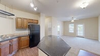 Located at 140 N Davis Rd in LaGrange, Georgia, this single-story, 3-bedroom, 2-bathroom home offers a functional and well-appointed layout. The combined kitchen and dining area serves as the heart of the home, showcasing warm wood cabinetry, dark granite countertops, a peninsula island, track lighting, and black appliances including a range and refrigerator. Hardwood-style flooring in the kitchen transitions smoothly into the carpeted living room, which features a ceiling fan and a glass-paneled door that fills the space with natural light. A hallway connects the living areas to the three bedrooms, each carpeted and featuring windows with blinds that allow for natural light. The spacious primary bedroom includes a ceiling fan and connects conveniently to one of the two bathrooms, which features hardwood-style flooring, a rich wood vanity with dark granite countertop, a large mirror, and stylish overhead lighting. Additional highlights include three closets for ample storage and a dedicated laundry area. The neutral, warm beige tones throughout the home create a cohesive and inviting ambiance, making this residence a comfortable and practical living space.