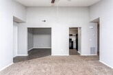 This single-floor residence in Macon, Georgia, offers a practical and comfortable layout designed for everyday living. The interior is finished with a neutral gray color palette throughout, creating a cohesive and clean aesthetic from room to room.

The kitchen is well-appointed with ample white cabinetry providing generous storage, light-toned countertops, and a full suite of black appliances including an electric range, refrigerator, and dishwasher. Light wood-look flooring runs through the kitchen, adding warmth to the functional space.

The living areas are carpeted in a neutral brown tone, lending a comfortable feel underfoot. A spacious room features sliding glass doors dressed with vertical blinds, allowing abundant natural light to pour in while offering access to the outdoors. Ceiling fans with light fixtures are present in multiple rooms, enhancing air circulation and illumination.

One bedroom showcases notably elevated ceilings, creating an open, airy atmosphere, and includes a recessed nook area that offers additional flexible space. Other bedrooms are well-sized with windows that invite natural light and ceiling fan fixtures overhead.

The bathroom is neatly finished with wood-look flooring, a gray-toned vanity with stone-look countertop, a large mirror, chrome hardware, and a full tub-shower combination. Clean white walls and bright lighting complete the polished look of this well-maintained Macon home.