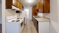 Located in Lakewood, WA, this two-bedroom, two-bathroom unit offers a practical and well-organized single-floor layout. The galley-style kitchen is equipped with warm wood cabinetry, a white electric range, dishwasher, refrigerator, and generous counter space on both sides — making efficient use of the space. The kitchen flows seamlessly into the combined dining and living area, which features durable wood-look vinyl flooring and a textured ceiling throughout. The living space is bright and open, with a sliding door providing access to a private balcony.

Both bedrooms are carpeted and include natural light from windows with views of surrounding greenery. Each bedroom benefits from dedicated closet space — with six closets total throughout the unit, offering ample storage. The primary bedroom is comfortably sized with its own closet access.

The two bathrooms are clean and functional. One features a full tub/shower combo with a single-sink vanity and in-unit washer, while the second offers a single-sink vanity with wood cabinetry and vinyl flooring. A hallway connects the main living areas to the bedrooms and bathrooms, contributing to a logical and easy-to-navigate floor plan. Baseboard heating is present in the bedrooms for year-round comfort.