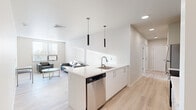 Located on Lincoln Ave in Amherst, MA, this contemporary 3-bedroom, 6-bathroom unit offers a thoughtfully designed single-floor layout with modern finishes throughout. The open-concept kitchen and living area serves as the heart of the home, featuring a sleek white quartz peninsula with an undermount sink and bar seating, stainless steel appliances including a refrigerator, electric range, microwave, and dishwasher, and light wood cabinetry. Pendant lighting with matte black cylindrical fixtures adds a modern touch overhead. The living area is bright and airy, with large windows fitted with horizontal blinds that invite abundant natural light, and light-toned hardwood-style flooring that runs seamlessly throughout the entire unit. Each of the three bedrooms offers a clean, minimalist space suitable for both rest and study. The six bathrooms are finished with warm wood vanities, light flooring, and chrome fixtures; some feature a full tub-shower combination, while others are appointed as half-baths. An in-unit laundry closet houses a full-sized Whirlpool washer and dryer with built-in shelving above. Multiple hallways provide easy navigation throughout the unit. The overall aesthetic is clean, modern, and functional, making this a well-appointed space in the Amherst community.