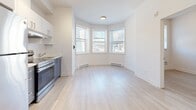 Located at 2238 Rue du Souvenir in Montréal's vibrant Notre-Dame-de-Grâce neighbourhood, this two-bedroom, one-bathroom unit offers a clean, modern interior with a bright and airy feel. Light wood-toned flooring runs throughout the space, creating a warm, cohesive aesthetic.

The open kitchen and living area is a standout feature, anchored by a striking bay window that floods the room with natural light and offers pleasant street-level views. The kitchen is outfitted with white upper cabinetry, blue-grey lower cabinets, a white subway tile backsplash, and a stainless steel range, providing a functional and stylish cooking space.

The primary bedroom is generously proportioned and features a dedicated closet, while the second bedroom is a compact, well-lit room with its own window and baseboard heating. Both rooms benefit from the consistent light wood flooring and neutral white walls that define the unit's clean aesthetic.

The bathroom is neatly finished with white large-format wall tiles surrounding a full bathtub and shower combination, complemented by a white vanity with a mirror and grey floor tiles.

Baseboard heaters are present throughout, ensuring year-round comfort. The unit's bright, minimalist design makes it a practical and inviting space in the heart of Montréal.
