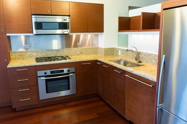 Cocina completamente equipada con gabinetes de primera calidad, encimeras de granito, electrodomésticos de acero inoxidable, estufa a gas e iluminación debajo de los gabinetes. - 3601 SW River Pkwy