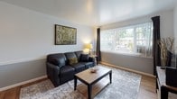 Located at 1227 N Hancock Ave in Colorado Springs, CO, this single-floor residence offers a well-organized layout with a cohesive design aesthetic throughout. The living area is a comfortable, light-filled space featuring hardwood-style flooring, neutral gray walls with contrasting white trim, and a large window dressed with vertical blinds and dark drape panels that allow natural light to fill the room. The space flows naturally into a dedicated dining area, distinguished by two-tone wall treatment and a floating shelf, creating an intimate setting for everyday meals.

The kitchen is efficiently designed with dark granite countertops, stainless steel appliances including an electric range, and sleek cabinetry with modern hardware. A window above the counter provides natural light and an outdoor view. The bold black-and-white checkered tile flooring adds a striking visual element that also carries through into the bathroom.

The bedroom offers a calm, restful atmosphere with hardwood-style flooring, a ceiling light fixture, and ample window coverage for light control. Two-tone wall treatment adds subtle architectural interest to the room.

The full bathroom is cleanly appointed with a pedestal sink, mirrored medicine cabinet, a shower-tub combination, and the signature checkered tile flooring, tying the overall design together cohesively.